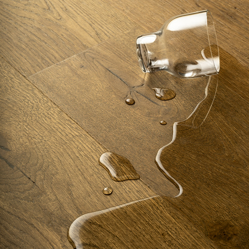 glas of water spilled on a wooden floor